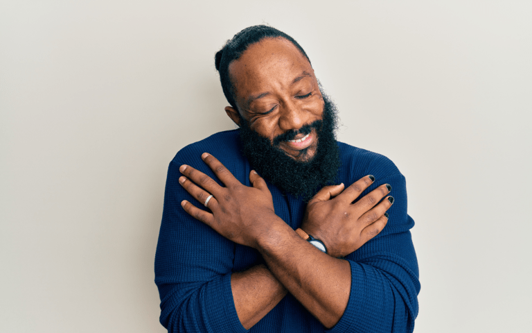 一个12分钟的冥想提醒自己已经足够——一位留着胡须、穿着深蓝色衬衫的黑人男子给自己一个拥抱。