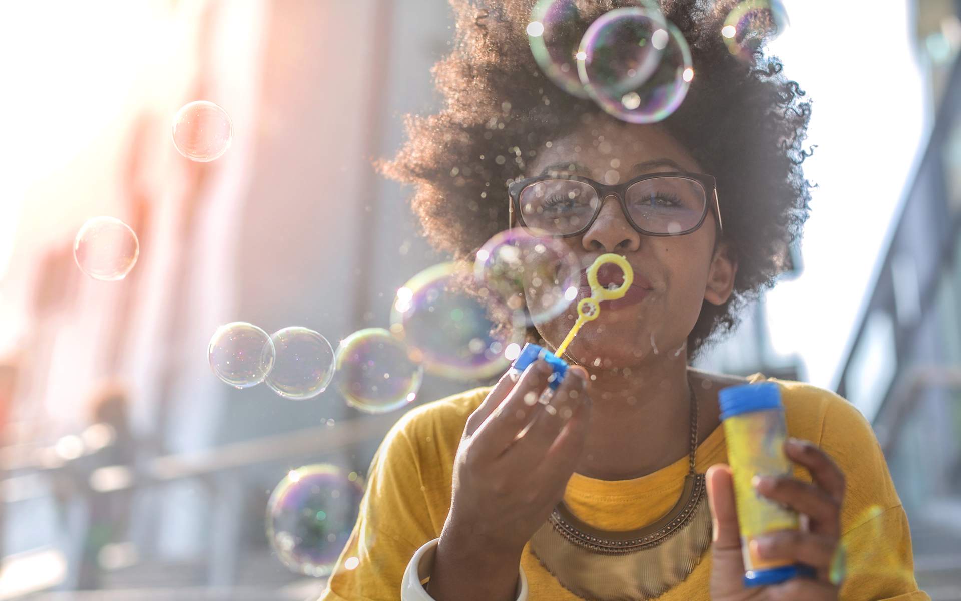 通过正念练习重获你的快乐 - 一位黑人女性在户外吹肥皂泡