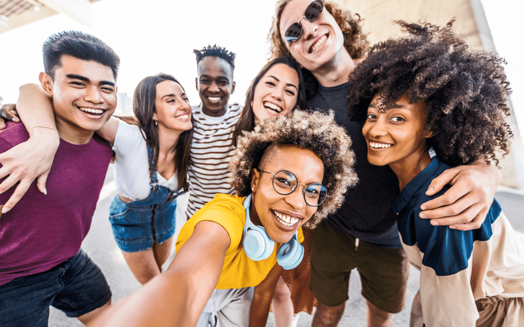 一群不同背景的青少年微笑着聚集在一起自拍的照片。