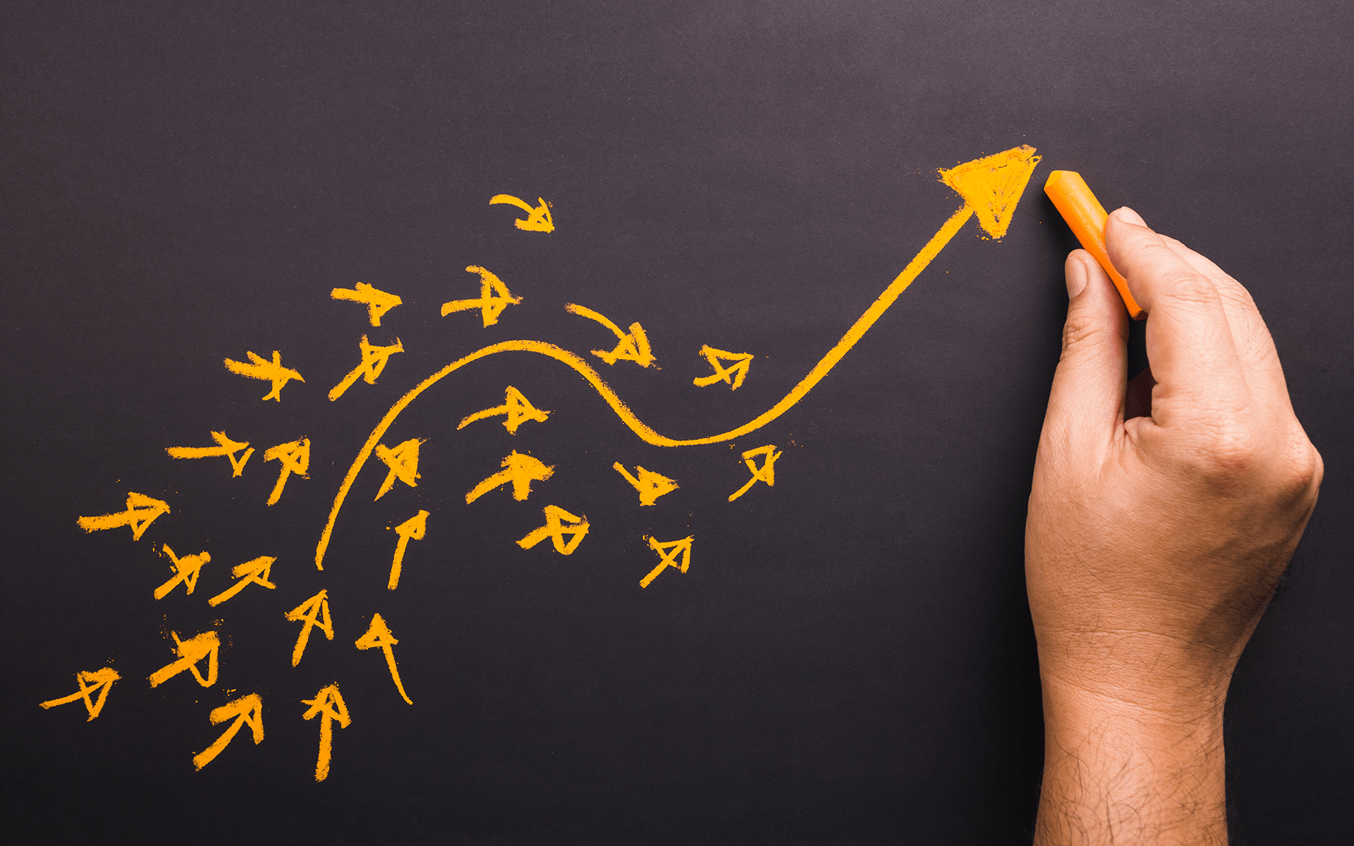 一张白手在黑板上画黄色箭头的照片，箭头向上并向右指。