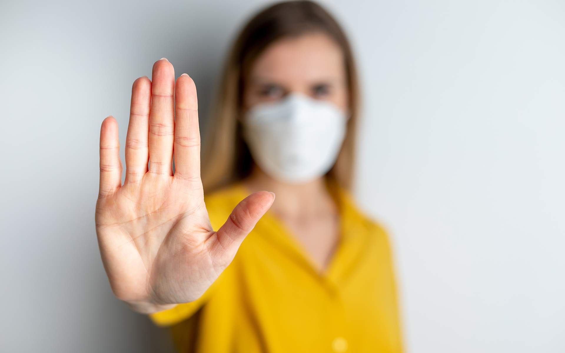 Woman wearing face protection in prevention of coronavirus showing gesture