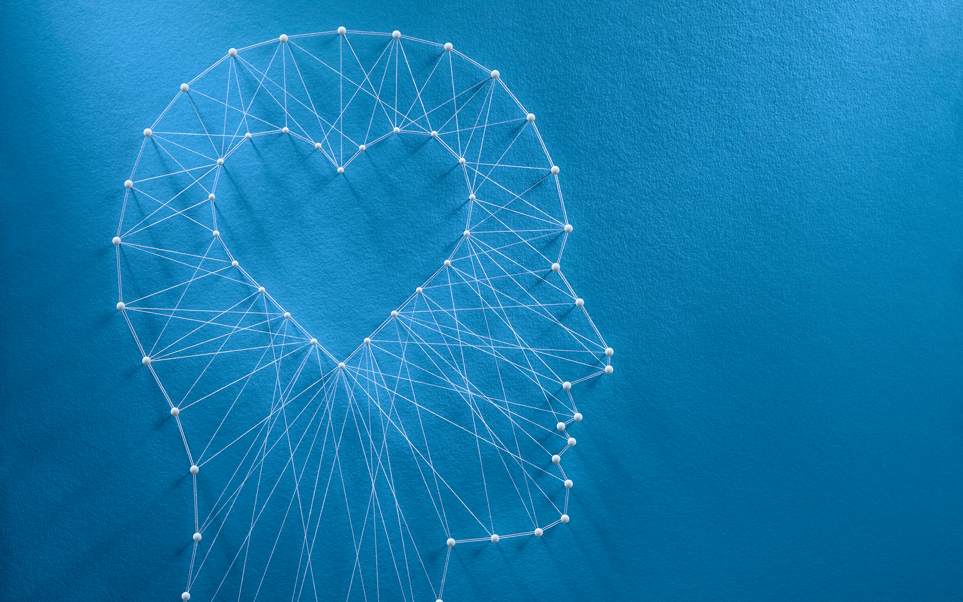 使用自我同情帮助应对反复抑郁—蓝色背景上的用线连接形成的一个人头形状和中间的心形